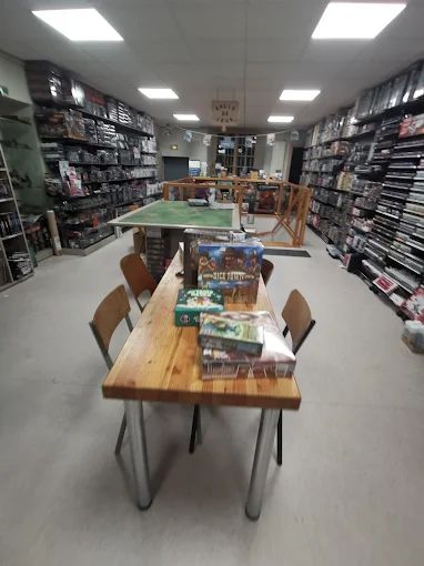 Tables de jeu installées dans le magasin, avec des boîtes de jeux posées dessus
